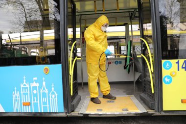 Lviv, Ukrayna, 03 Mart 2020. İşçiler otobüs durağına vardıktan sonra bir tramvayı dezenfekte ettiler. İlk Coronavirus Covid-19 vakası Ukrayna 'da doğrulandı..