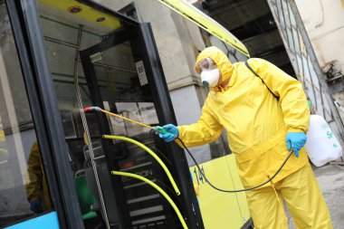 Lviv, Ukrayna, 03 Mart 2020. İşçiler otobüs durağına vardıktan sonra bir tramvayı dezenfekte ettiler. İlk Coronavirus Covid-19 vakası Ukrayna 'da doğrulandı..
