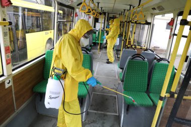 Lviv, Ukrayna, 03 Mart 2020. İşçiler otobüs durağına vardıktan sonra bir tramvayı dezenfekte ettiler. İlk Coronavirus Covid-19 vakası Ukrayna 'da doğrulandı..