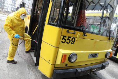 Lviv, Ukrayna, 03 Mart 2020. İşçiler otobüs durağına vardıktan sonra bir tramvayı dezenfekte ettiler. İlk Coronavirus Covid-19 vakası Ukrayna 'da doğrulandı..
