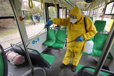 Lviv, Ukrayna, 03 Mart 2020. İşçiler otobüs durağına vardıktan sonra bir tramvayı dezenfekte ettiler. İlk Coronavirus Covid-19 vakası Ukrayna 'da doğrulandı..