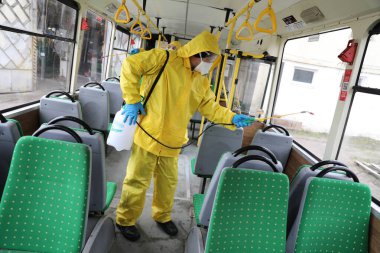 Lviv, Ukrayna, 03 Mart 2020. İşçiler otobüs durağına vardıktan sonra bir tramvayı dezenfekte ettiler. İlk Coronavirus Covid-19 vakası Ukrayna 'da doğrulandı..