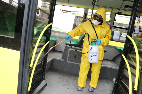 Lviv, Ukrayna, 03 Mart 2020. İşçiler otobüs durağına vardıktan sonra bir tramvayı dezenfekte ettiler. İlk Coronavirus Covid-19 vakası Ukrayna 'da doğrulandı..