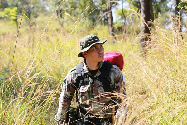 Man Traveler with backpack trekking in forest