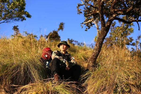 Man Traveler with backpack trekking in forest