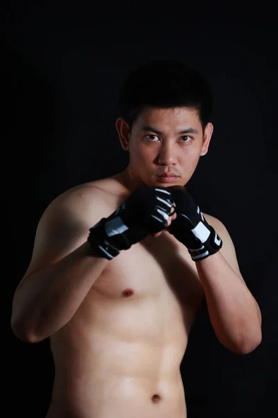 Asiático lutador boxer de pé forte no fundo preto — Fotografia de Stock