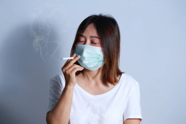  Genç kadın sigara Sigara İçilmeyen kavramı koruyucu maske ile durdurmak