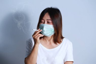  Genç kadın sigara Sigara İçilmeyen kavramı koruyucu maske ile durdurmak
