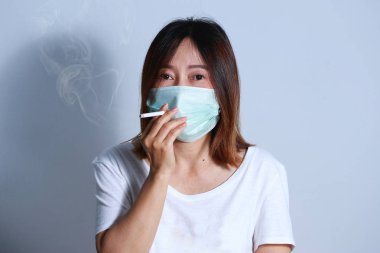  Genç kadın sigara Sigara İçilmeyen kavramı koruyucu maske ile durdurmak