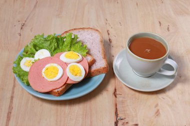yumurtalı sandviç ve kahve ahşap masa üzerinde basit kahvaltı