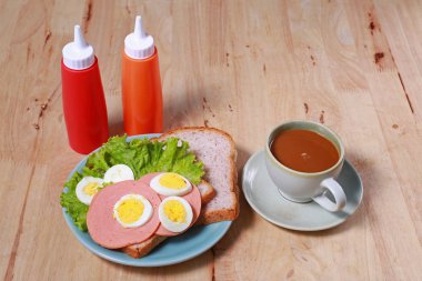 yumurtalı sandviç ve kahve ahşap masa üzerinde basit kahvaltı