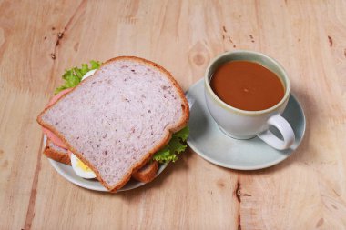 yumurtalı sandviç ve kahve ahşap masa üzerinde basit kahvaltı