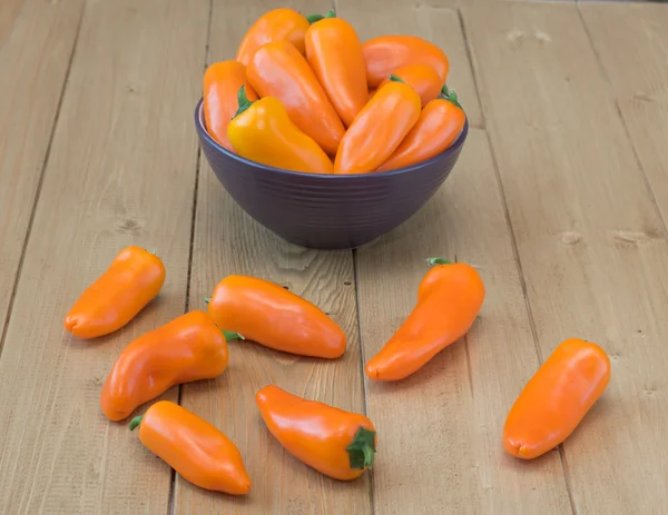 Orange bell pepper in a bowl on a wooden table. — Stock Photo, Image