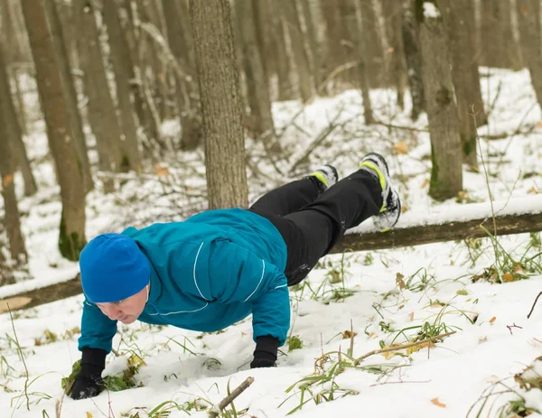 Чоловік виконує вправи в зимовому лісі . — стокове фото