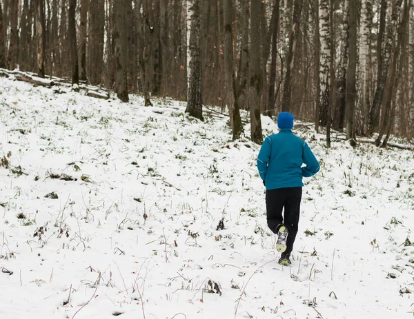 Mężczyzna lubi biegać w lesie zimą. — Zdjęcie stockowe