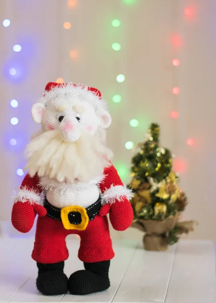 Brinquedo de malha Papai Noel em um fundo de bokeh colorido . — Fotografia de Stock