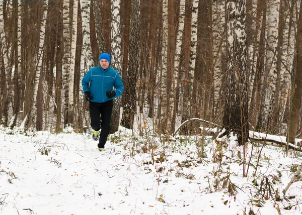 Mężczyzna lubi biegać w lesie zimą. — Zdjęcie stockowe