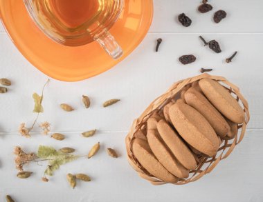 Zencefilli bisküvi ile beyaz ahşap bir masa üzerinde bitki çayı.