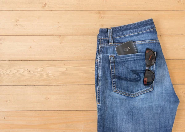 Pánské džíny a doplňky na dřevěnou podlahu. — Stock fotografie