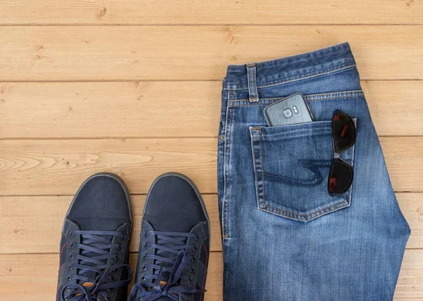 Pánské džíny a doplňky na dřevěnou podlahu. — Stock fotografie