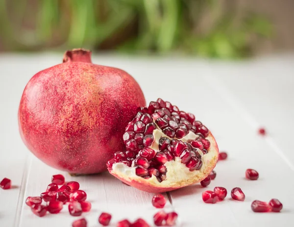 Graines de grenade mûres sur une table en bois blanc. Régime aux fruits. Mode de vie sain . — Photo