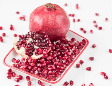 Olgun nar taneleri bir beyaz ahşap tablo.