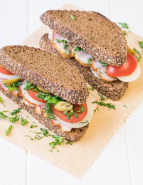 Taze bir beyaz tahta masada Jambonlu sandviç yaptı.