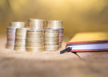 Metal paralar bir rustik masa üstünde bir defter ile. İş için aksesuarlar. Seçici odak.