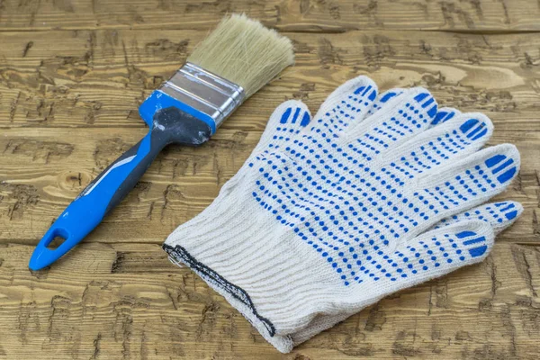 Cepillo con guantes en una mesa de madera . — Foto de Stock