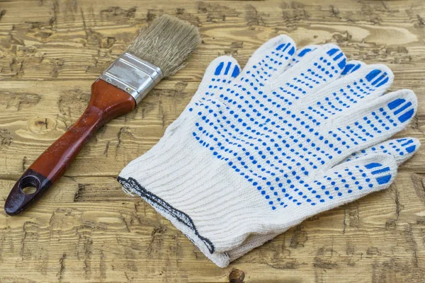 Cepillo con guantes azules en una mesa de madera . — Foto de Stock