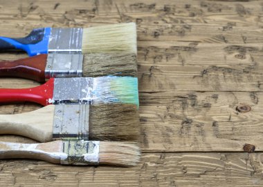 Rustik ahşap bir masa üzerinde beş çok renkli fırçalar.