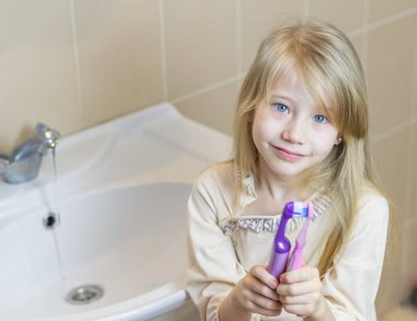 İki farklı diş fırçaları kız ellerini öpmek..