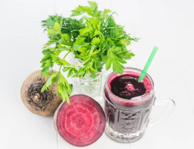 Taze pancar suyu bir bardak kupa Beyaz ahşap masa üzerinde otlar ile.