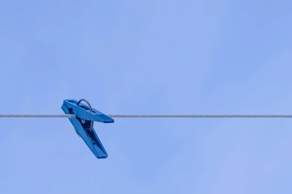 Blauwe kleding geselen aan een touw tegen een blauwe hemel. — Stockfoto