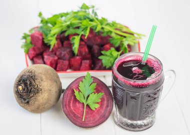 Kırmızı pancar ve pancar suyu Beyaz ahşap masanın üzerine dilimlenmiş.