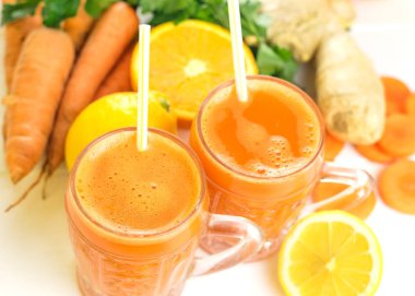 İki cam bardağı havuç güler yüzlü ve kokteyl kamış.