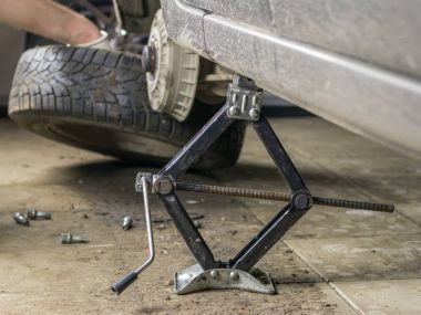 Bir Jack ile kaldırılan tekerlek üzerinde kaldırdı araba.