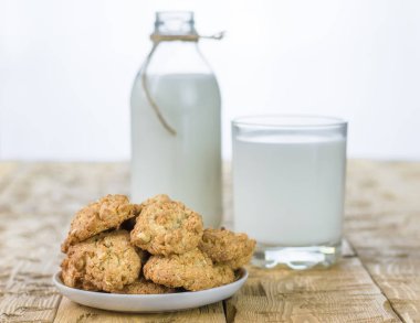 Un ve süt güzel bir masa üzerinde ev yapımı bisküvi ile kase.