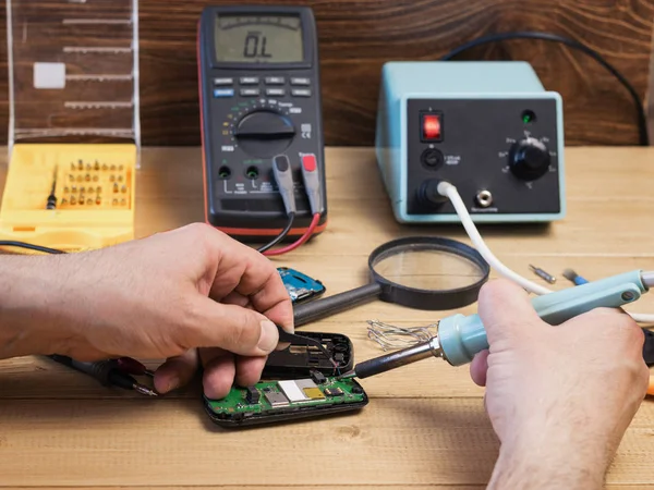 Componentes eléctricos de soldadura masculina en el teléfono móvil . — Foto de Stock