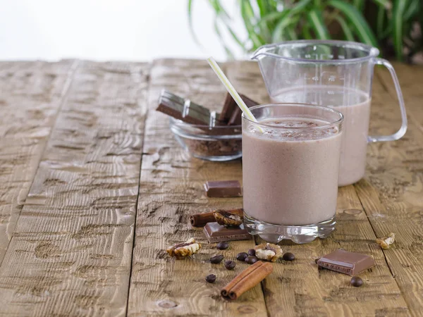 Bananen-Smoothie mit Zimt und Schokolade auf rustikalem Tisch. — Stockfoto