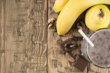 Çikolatalı meyve yüzlü üstten görünüm ahşap bir masa üzerinde.