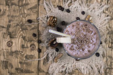 Çikolata muz smoothie ile fındık ve tarçın ahşap bir masa üzerinde. Bir vejetaryen diyet kavramı.