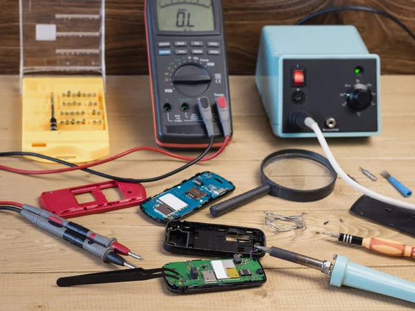 Söktüğünüz cep telefonlarında onarım için ahşap masa.