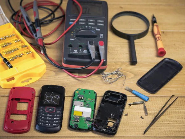 Dos teléfonos móviles desmontados en una mesa de madera . — Foto de Stock