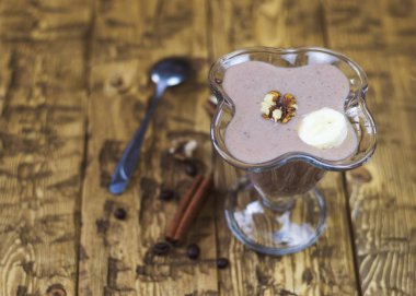 Ahşap bir masa üzerinde güzel bir vazo içinde çikolata muz smoothies.