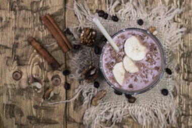 Ahşap bir masa üzerinde cevizli çikolatalı muz smoothie.