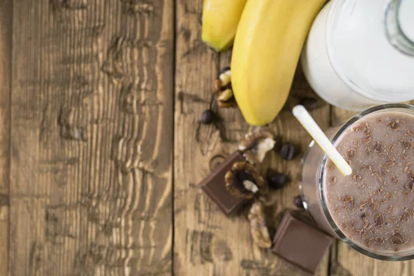 Sebotol susu dan coklat smoothie di atas meja pedesaan . — Stok Foto