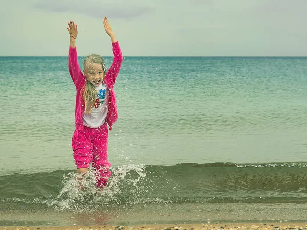 Sıcak elbiseli kız soğuk denizde çalış.