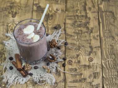 Çikolata-muz smoothie ve sarı-beyaz tüp ile bir bardak.