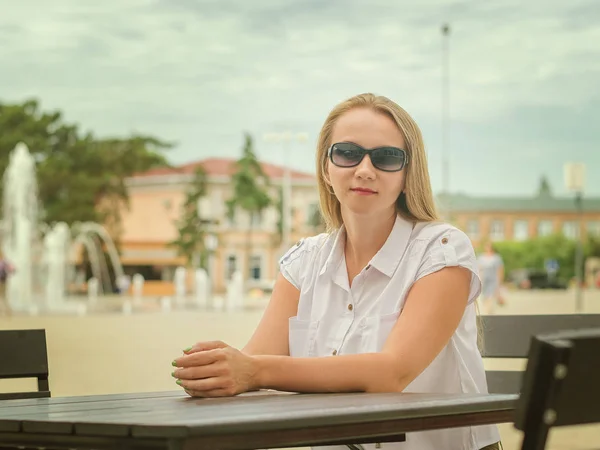 Mujer en gafas de sol en una mesa en el café de verano . — Foto de Stock